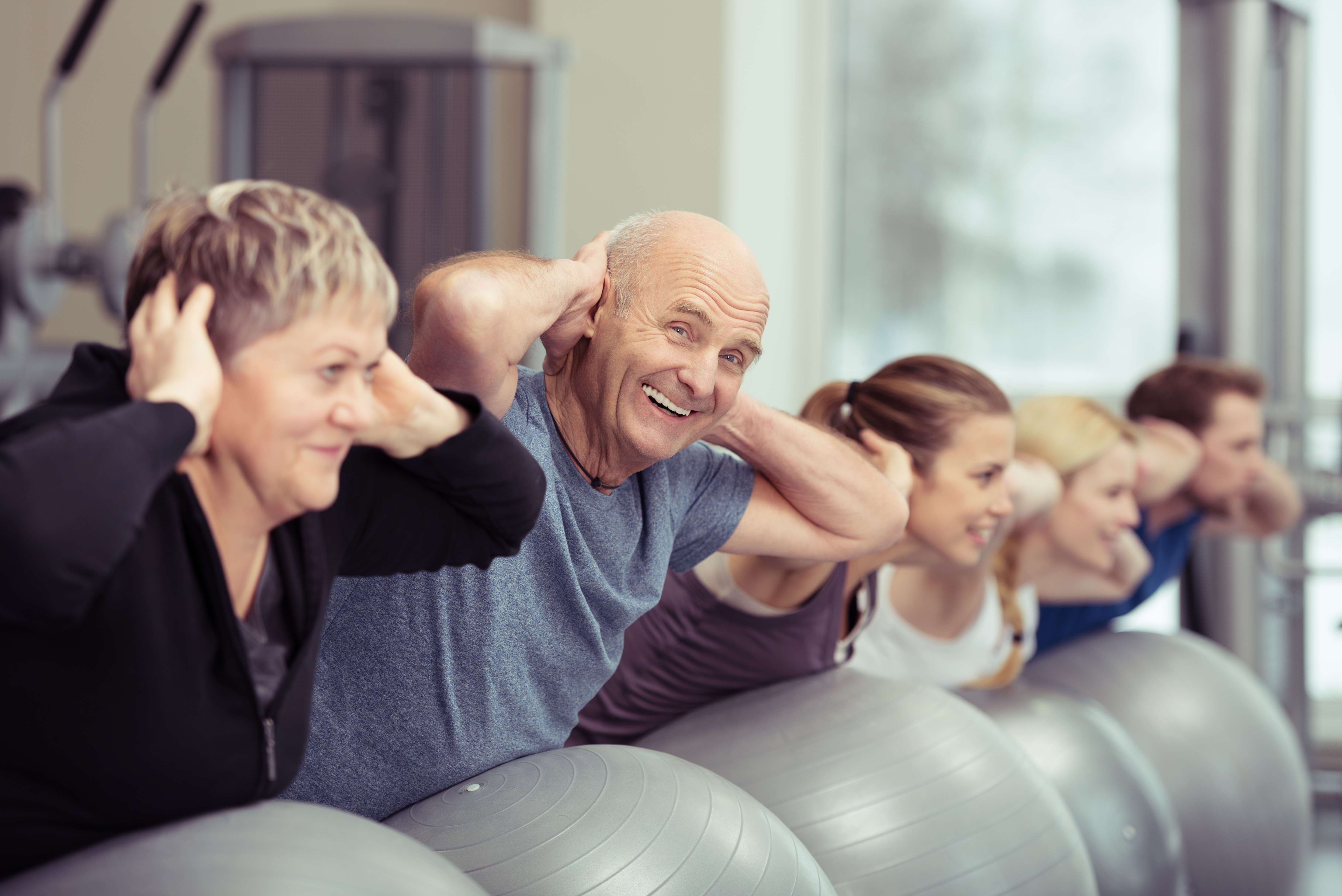 An older man participating in an exercise class with other people