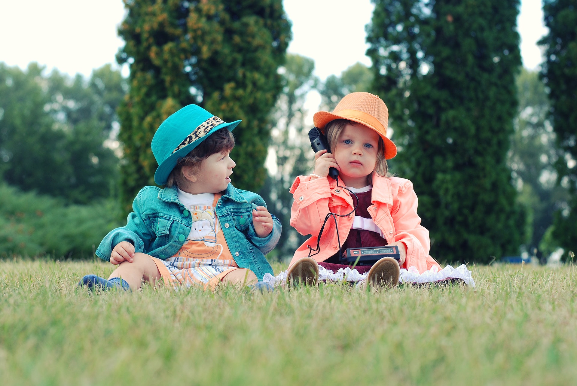 Two toddlers sitting in the park playing