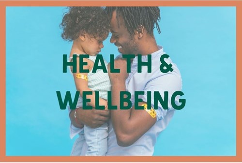 Man smiling and holding a toddler, with words Health and Wellbeing