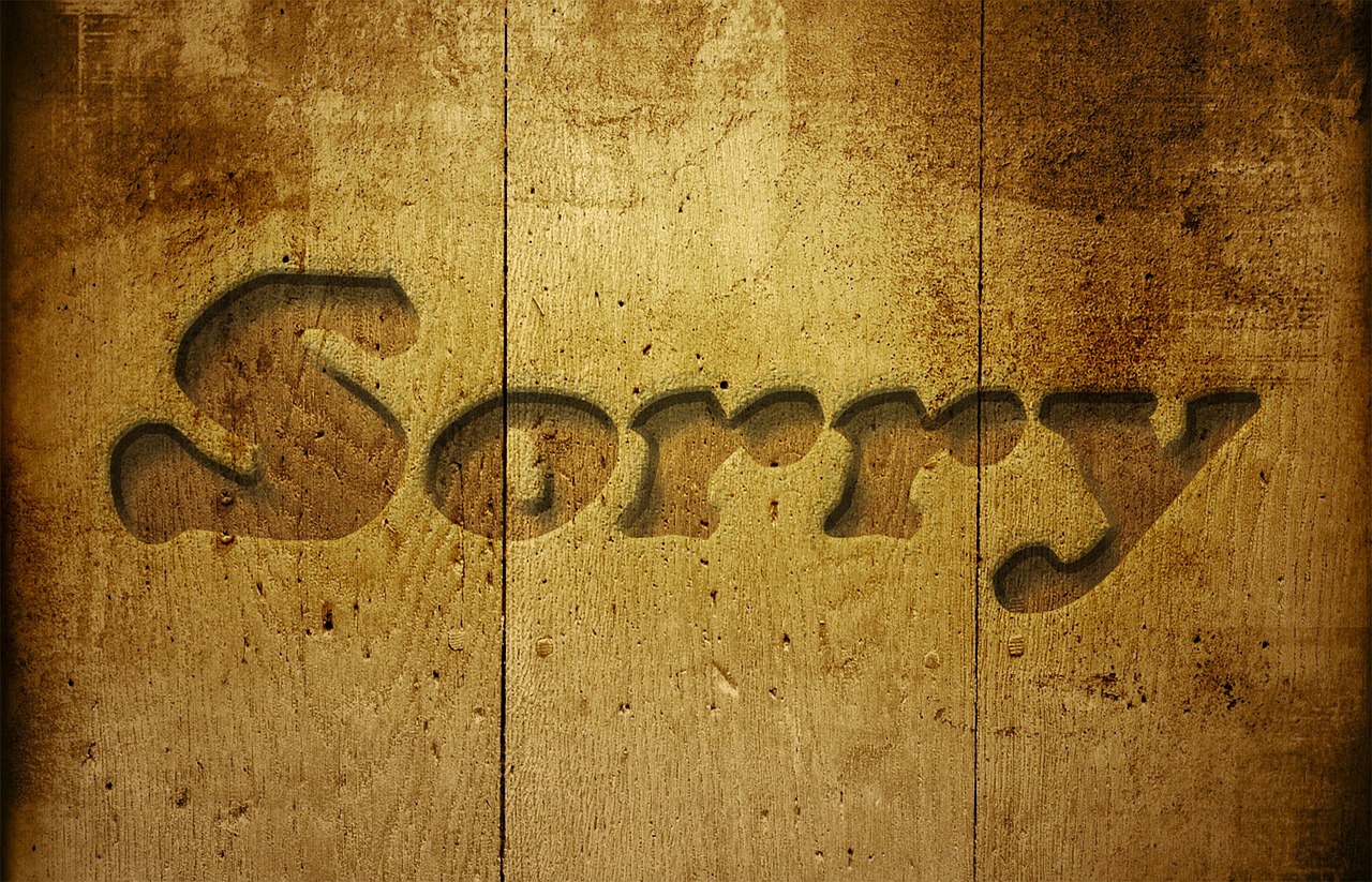 A wooden sign which says sorry