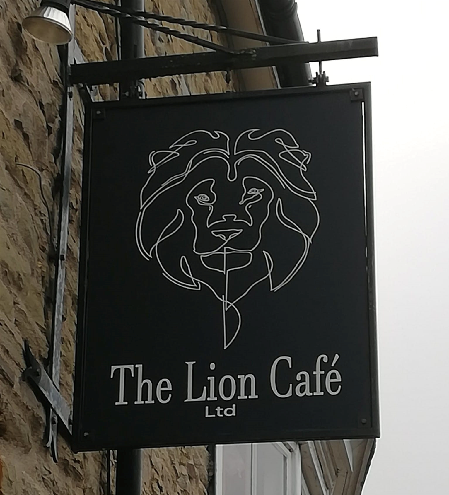 The black and white Lion Café exterior sign