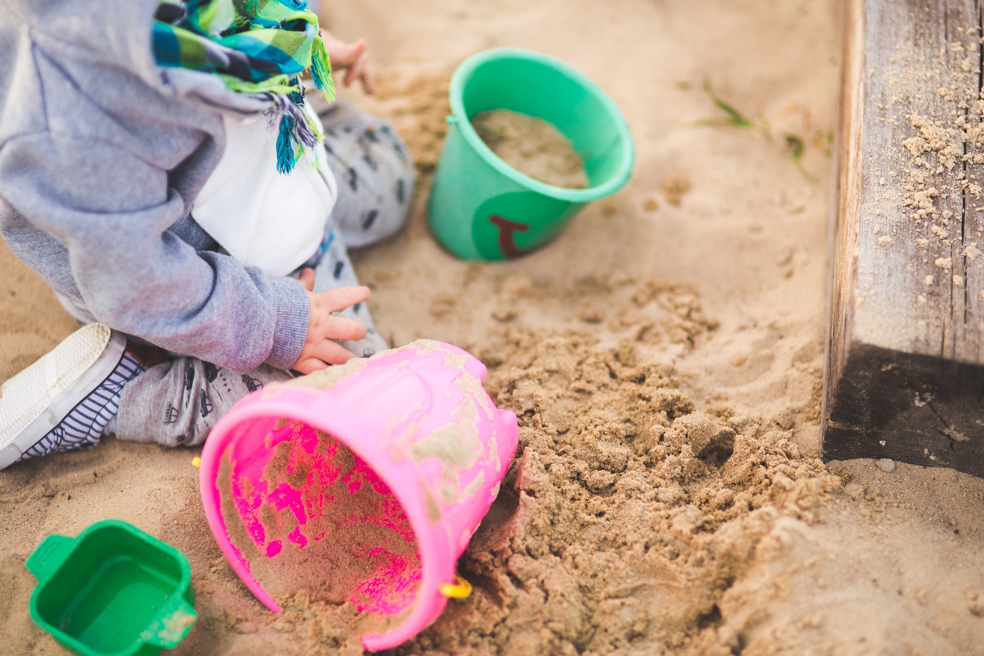 A toddler playing in the sandpit