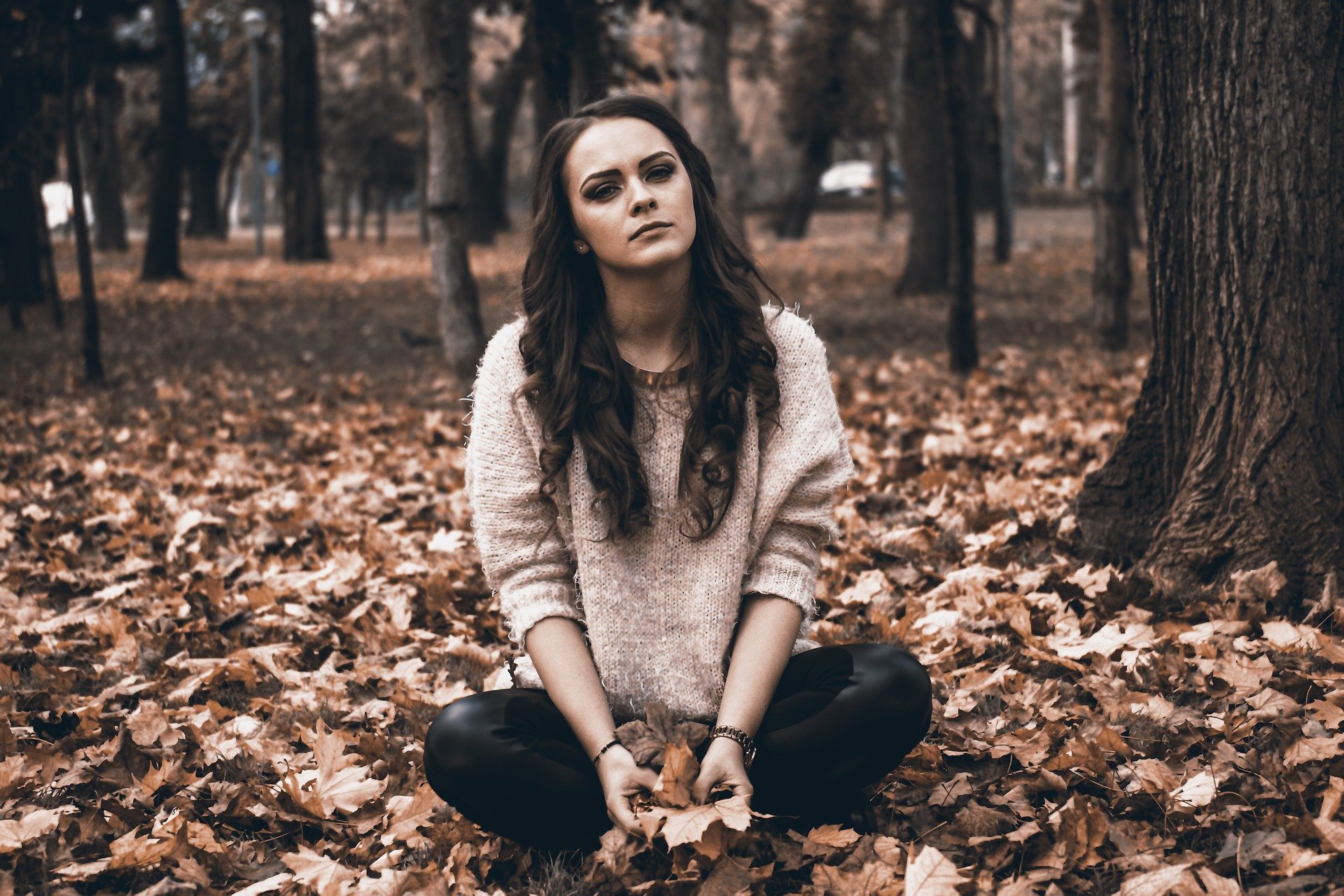 A photo of a teenage girl sitting in the park