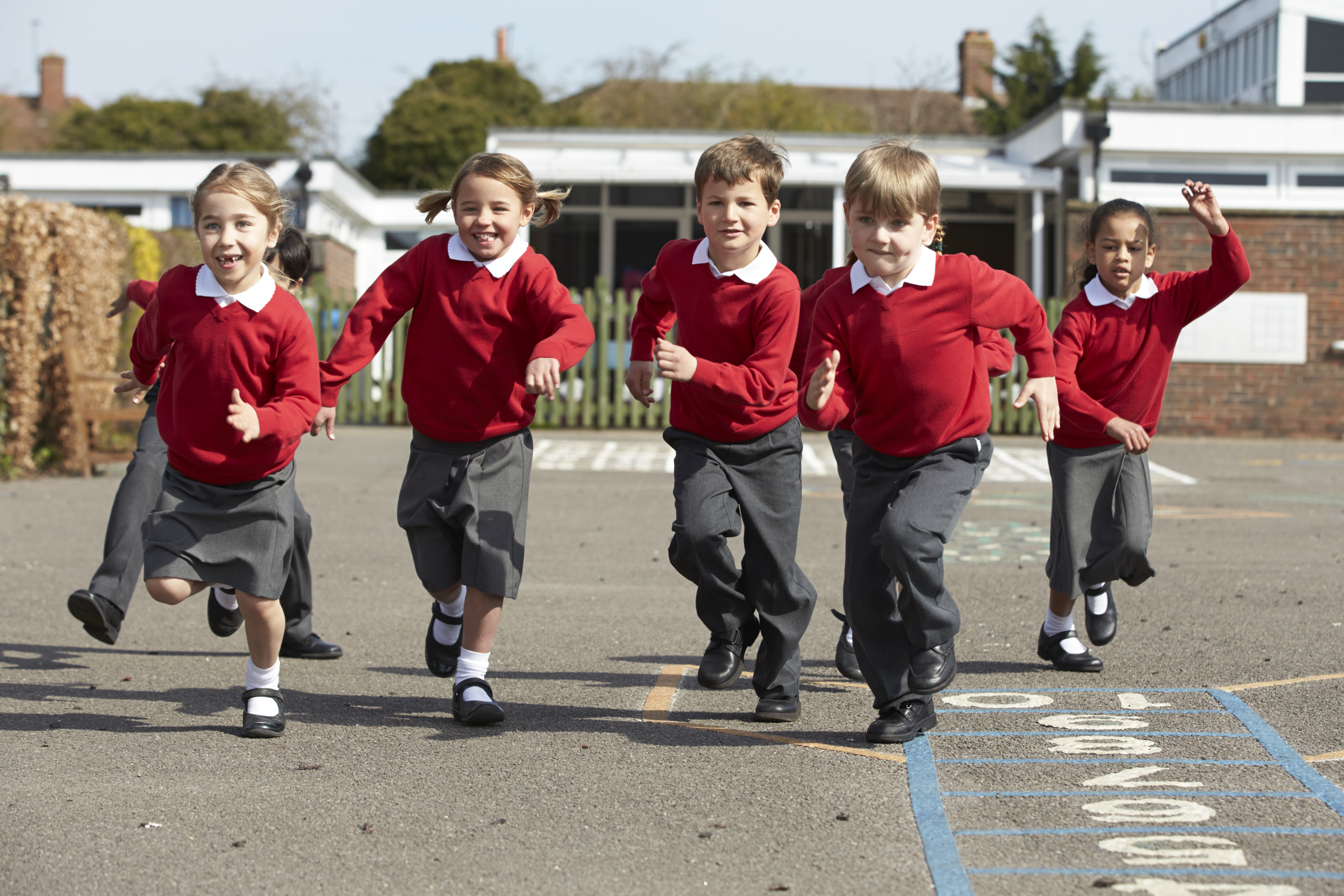 young children in school uniform running