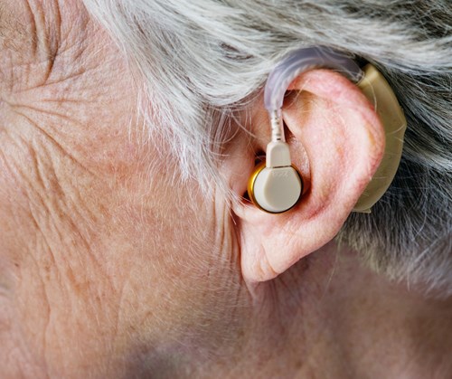 An older woman wearing a hearing aid