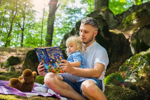A toddler and her dad reading together