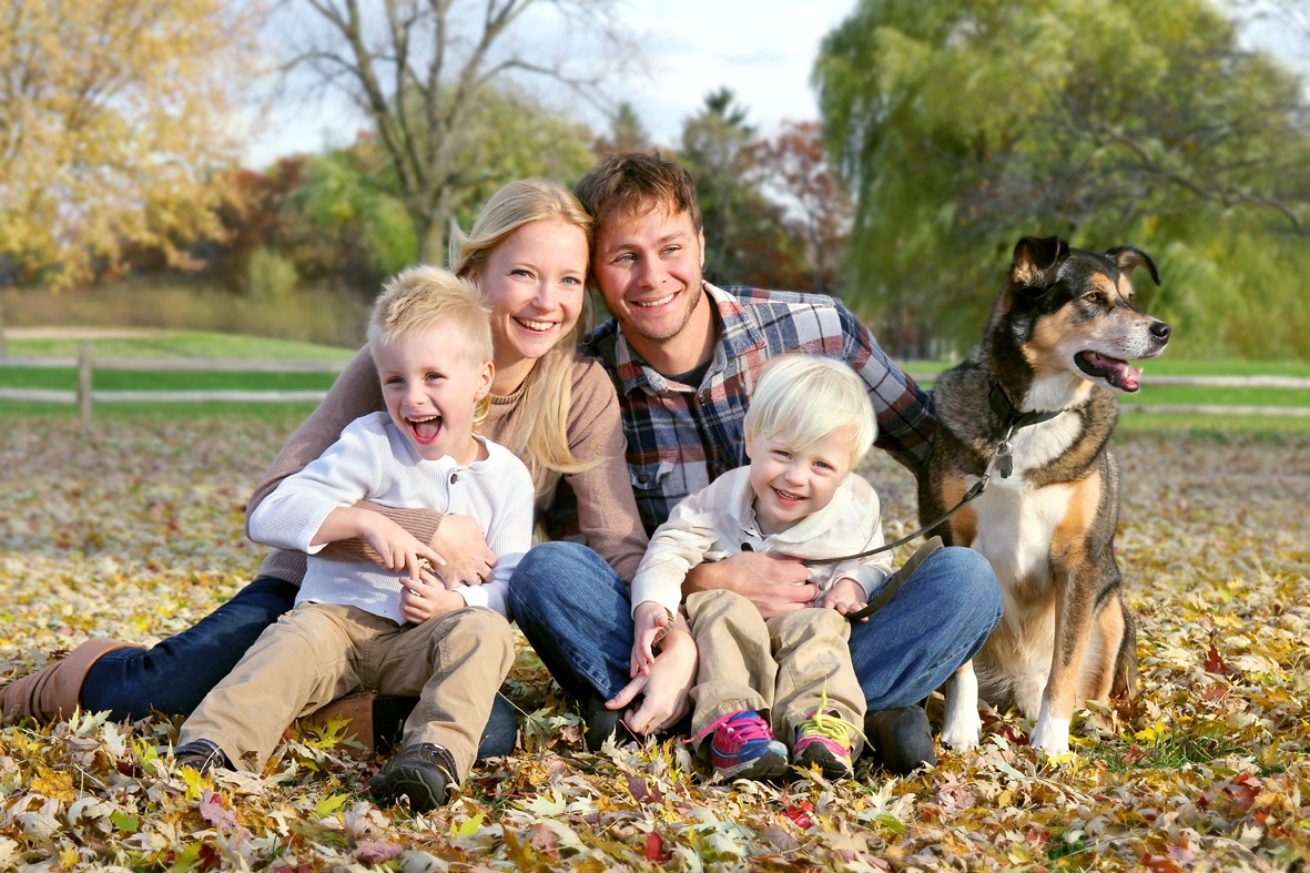 A family sitting in the park with their dog
