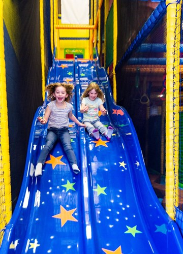 2 children going down a slide