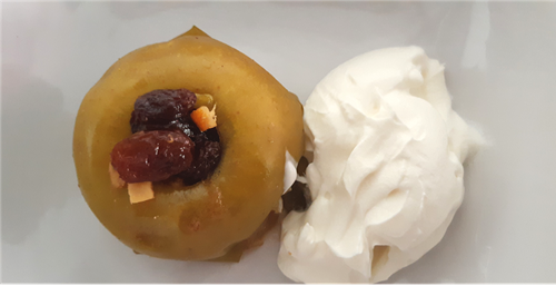 A baked apple filled with mincemeat, served with clotted cream