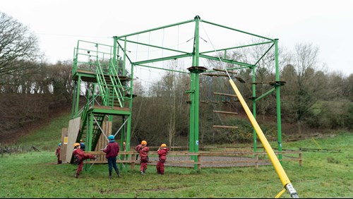 Image of outdoor climbing frame with children and instructor looking at it